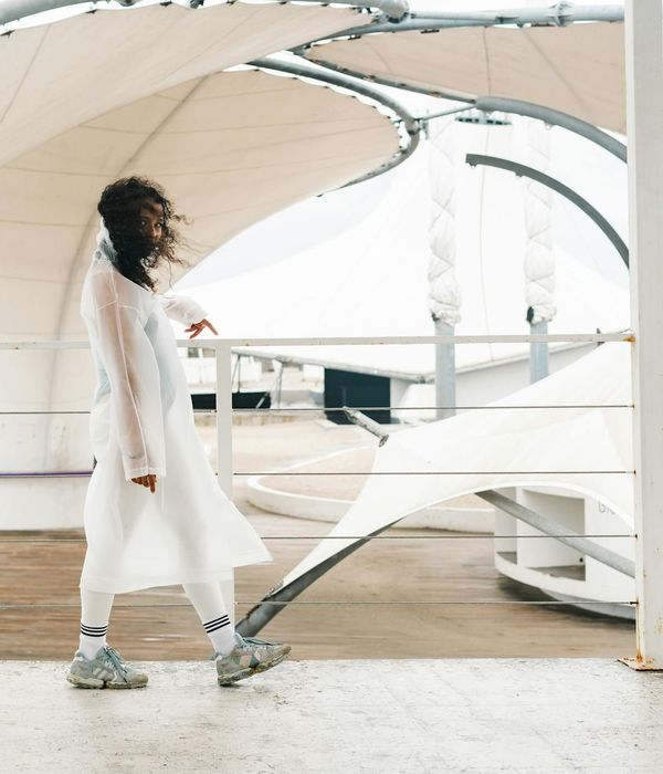 Woman performing a gentle cardio movement in a calm, minimalist space.